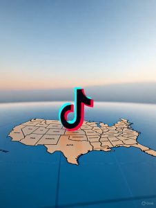 El texto alternativo (alt text) para la imagen generada sería: "Una imagen que muestra el logo de TikTok, compuesto por una nota musical estilizada en negro con detalles en colores verde, blanco y rojo, colocado sobre un mapa de los Estados Unidos. El mapa destaca los contornos de los estados en tonos beige y marrón, con un fondo azul que representa los océanos, y el logo de TikTok aparece centrado sobre la parte central del país.